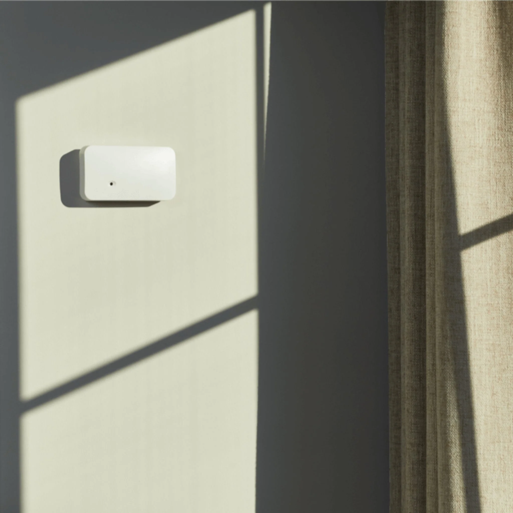 Sensor de rotura de cristales acústico instalado en la pared frente a una gran ventana para detectar intrusiones