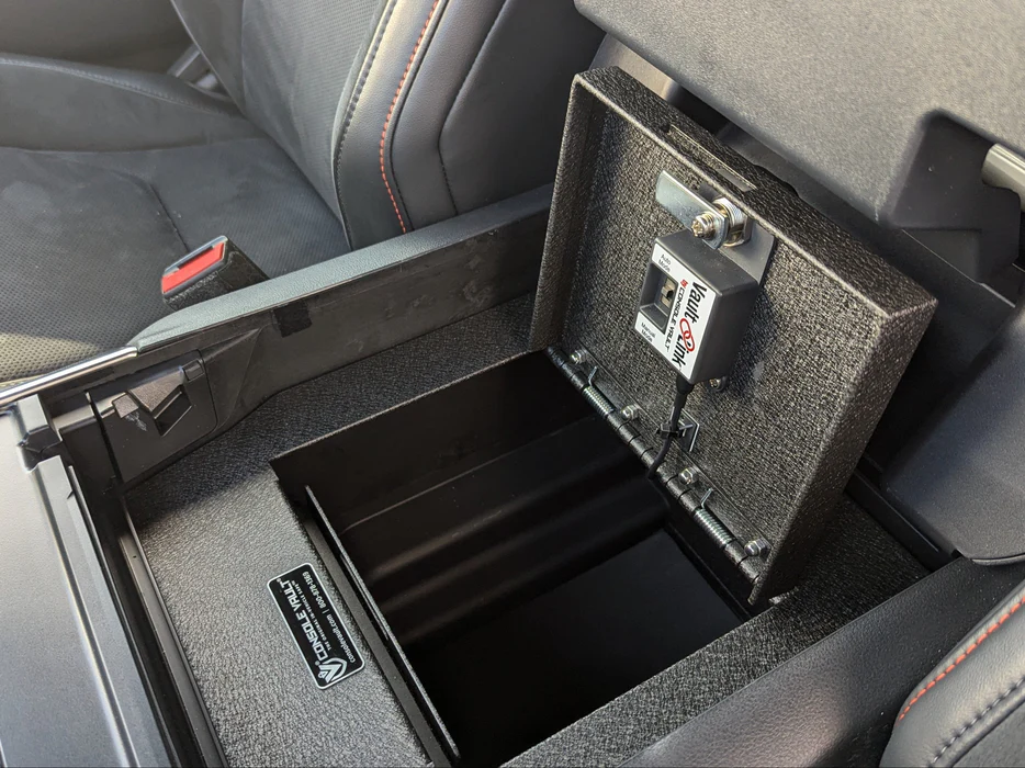 Caja fuerte a medida Console Vault instalada dentro del reposabrazos central de un vehículo
