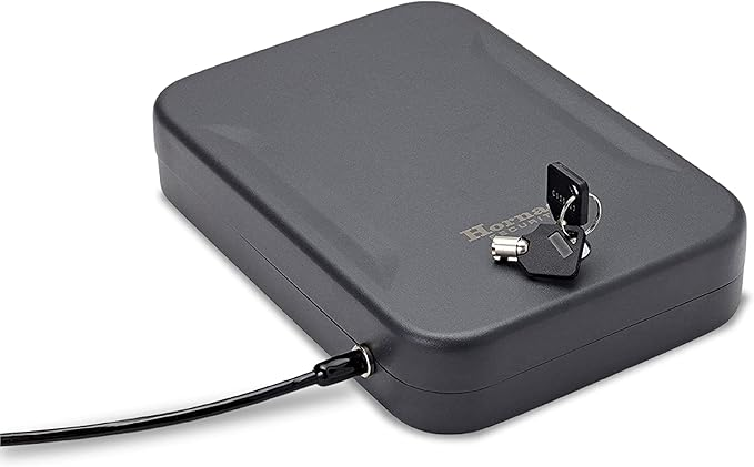 Caja de seguridad portátil Hornady TrekLite asegurada con cable de acero al marco del asiento del coche